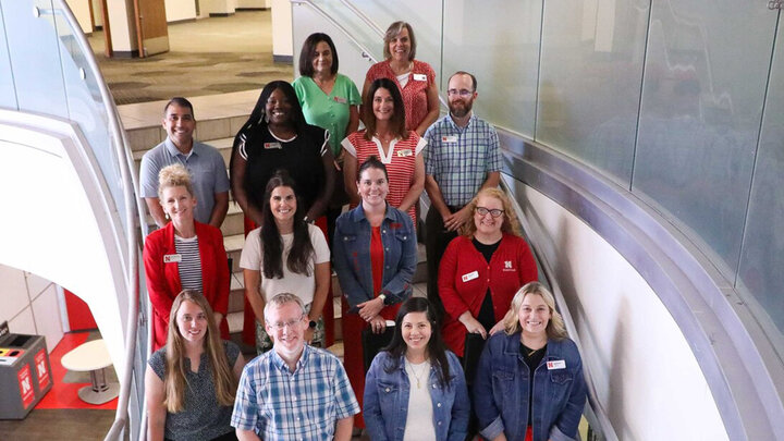 A group of staff members are photographed on a staircase.