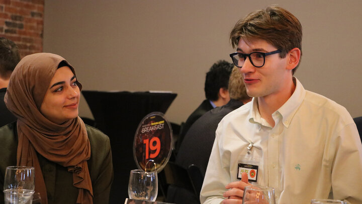 Alex Halvorsen (right), a University Honors student, talks during the Trailblazer's Breakfast on Sept. 11.