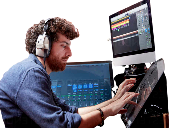 man with headphones and monitors typing on a flatscreen display