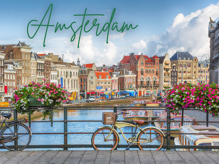 Bicycles and flower baskets on a canal bridge, colorful buildings in Amsterdam under a cloudy sky.