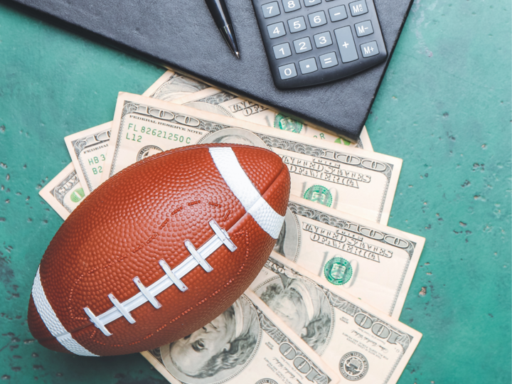 A football laying on hundred dollar bills