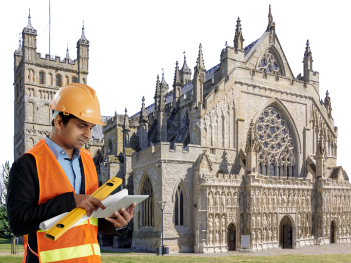 Man in construction safety wear in front of gothic cathedral