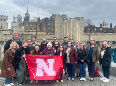 Honors students posing with a Husker flag in London